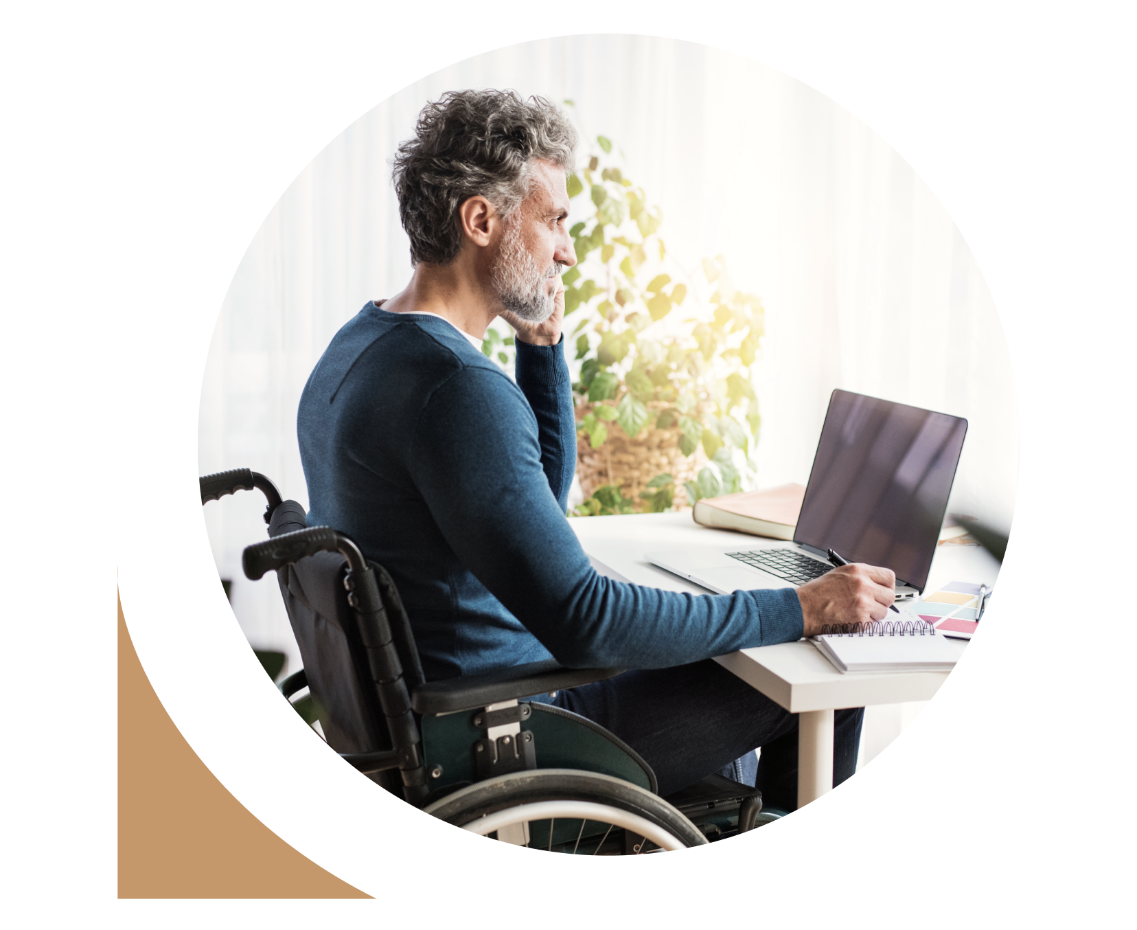 Un homme en fauteuil roulant passant un appel et rédigeant des notes avec son ordinateur